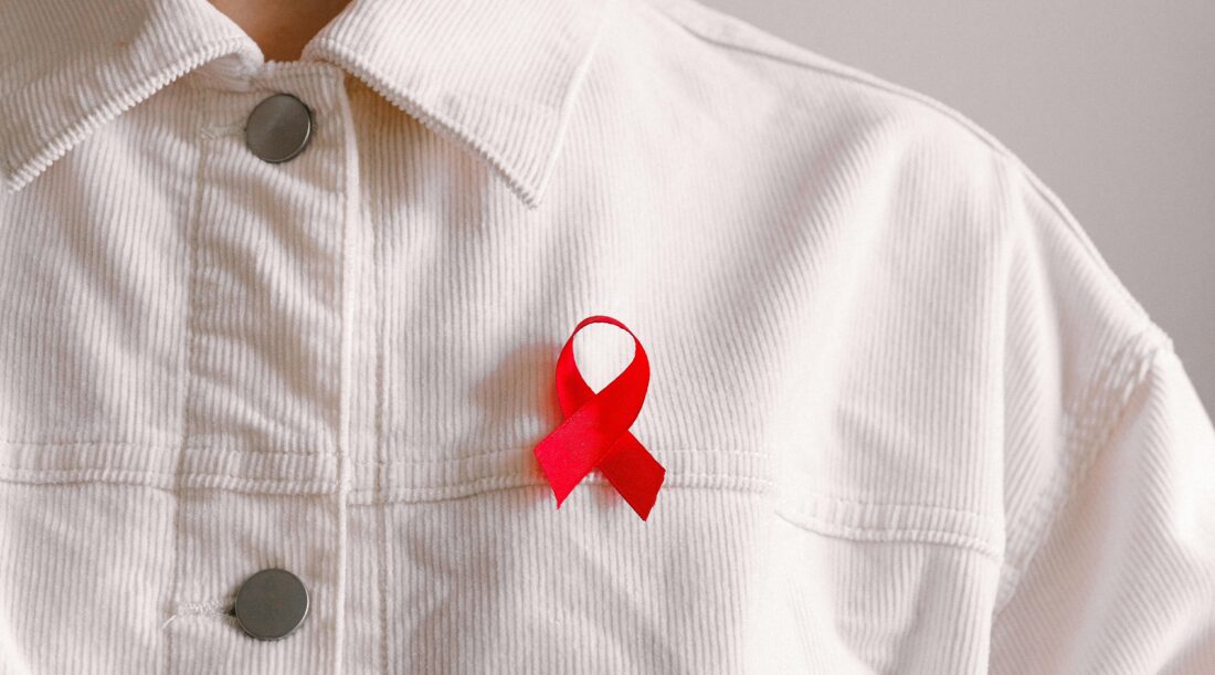 Red ribbon pinned on white shirt
