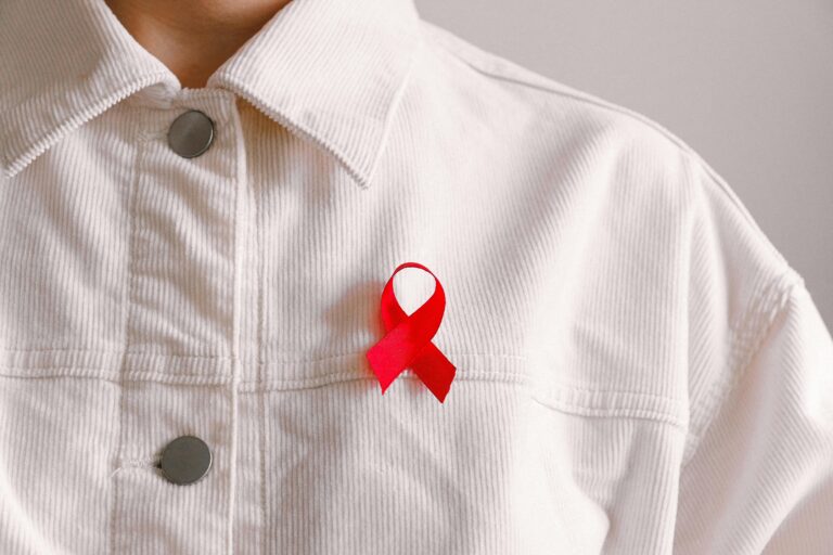 Red ribbon pinned on white shirt