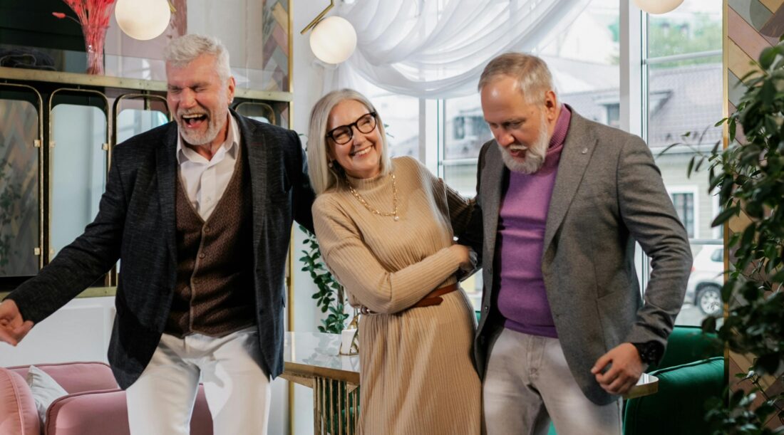 Two older men and a woman having fun at a party