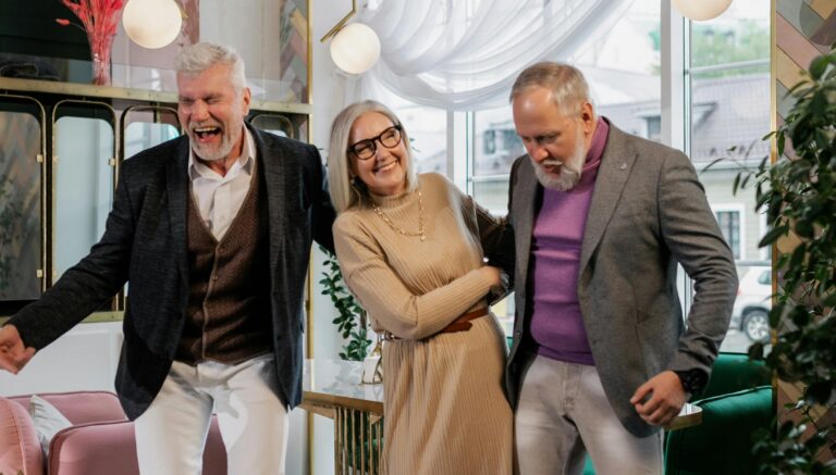 Two older men and a woman having fun at a party